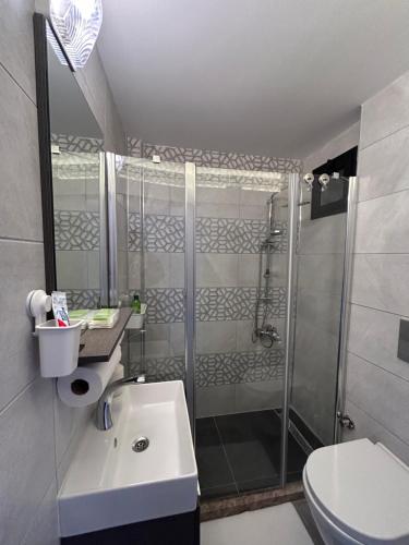 een badkamer met een douche, een wastafel en een toilet bij NG Homes in Kyrenia