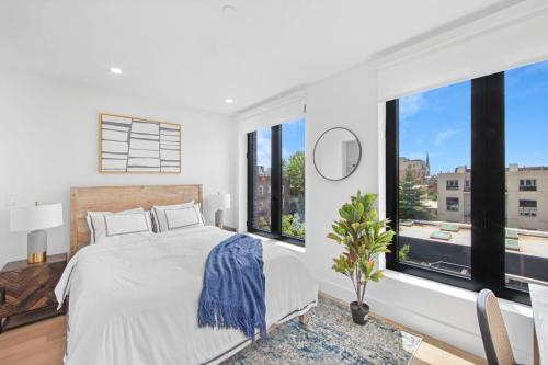 um quarto branco com uma cama grande e janelas grandes em 149BK-601 NEW PH 2BR-2Bath Private Rooftop W D em Brooklyn
