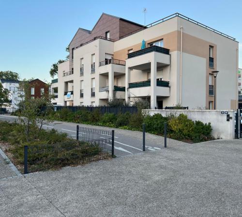 uma rua vazia em frente a um edifício em Appartement rez de chaussée avec parking privé em Orléans