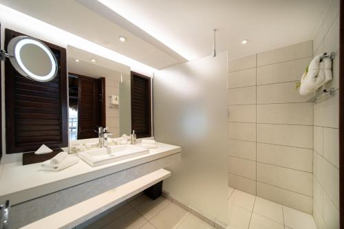 a bathroom with a sink and a mirror at Manava Beach Resort & Spa Moorea in Maharepa