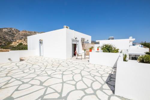 a view of a white house with a stone patio at Perama Hotel, Karpathos in Amoopi