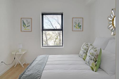 a white bedroom with a bed and a window at 108 Waverley in Cape Town