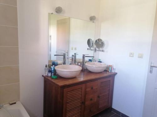 une salle de bain avec deux lavabos et un grand miroir dans l'établissement Jolie villa avec piscine, à Juvignac