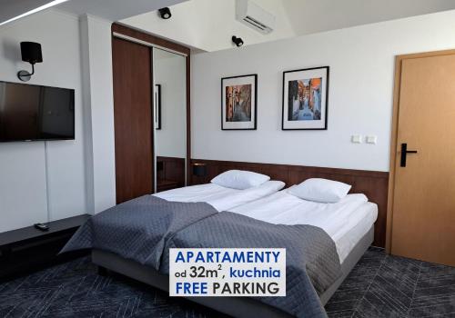 a hotel room with a bed and a tv at Warsaw Apartments - Apartamenty Wilanów in Warsaw