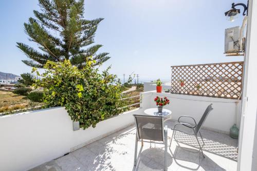 a balcony with a table and chairs and a christmas tree at Perama Hotel, Karpathos in Amoopi