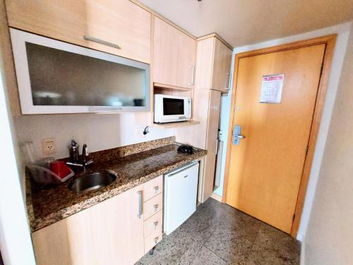 a small kitchen with a sink and a microwave at Lets Diária Brasil 64138 in Brasilia