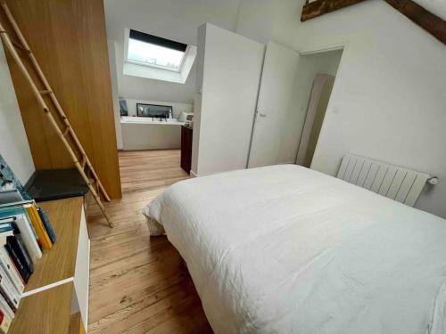 une chambre avec un lit blanc et un parquet dans l'établissement Maison familiale au calme, à Lorient