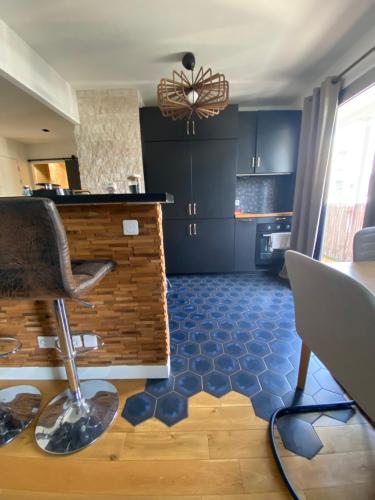 une cuisine avec des placards bleus et une chaise dans une pièce dans l'établissement Appartement cocooning, design, confort & Balcon, à Saint-Denis