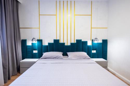 a bedroom with a large bed with a blue headboard at Poetic Apartment Vaslui in Vaslui