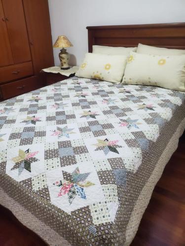 a bed with a quilt with butterflies on it at SUITE AMOBLADA CERCA DEL MALL DEL RIO in Cuenca