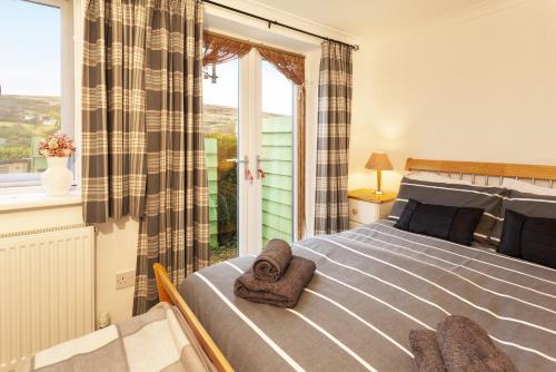 Un dormitorio con una cama grande con toallas. en Withymead Withypool, en Withypool