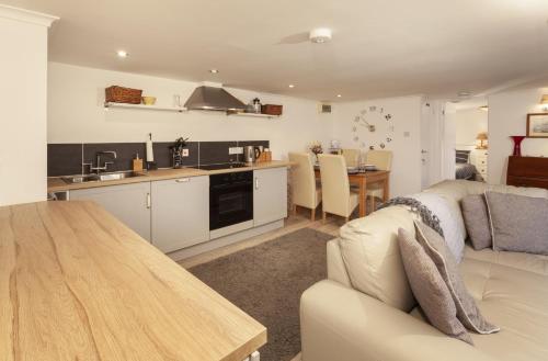 Una cocina y una sala de estar con un sofá y una mesa. en Withymead Withypool, en Withypool