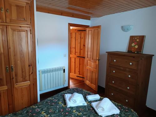 ein Schlafzimmer mit einem Bett und einer Kommode mit Handtüchern darauf in der Unterkunft Mar Tu Apartamento en Llanes in Llanes