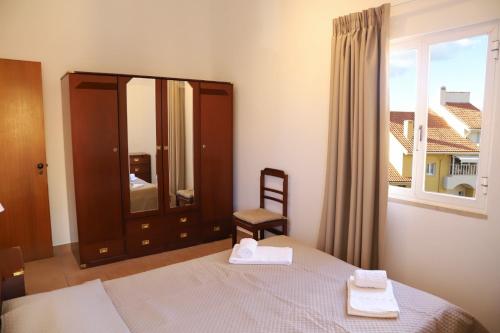 - une chambre avec un lit, un miroir et une chaise dans l'établissement Marina Plaza by Garvetur, à Vilamoura