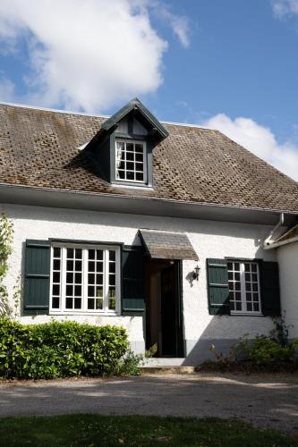 une maison blanche avec volets verts dans l'établissement Maison Maa , corps de ferme en entier, à 5 min de Saint Valery sur Somme à pieds le long du canal, à Boismont