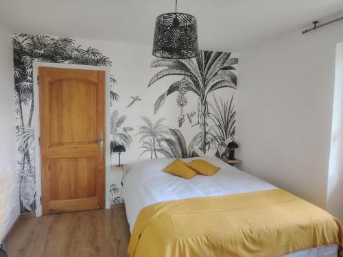 - une chambre dotée d'un lit avec des draps jaunes et du papier peint en palmier dans l'établissement Domaine des Petites Sœurs à 800m du centre historique avec 5200m2 de parc arboré, à Vence