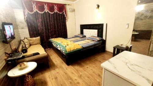 a bedroom with a bed and a couch in a room at Boutique Stay for Family On Manali Expressway in Lāndrān