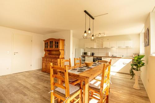 a kitchen and dining room with a wooden table and chairs at Helle Wohnung mit Stellplatz in Hermeskeil