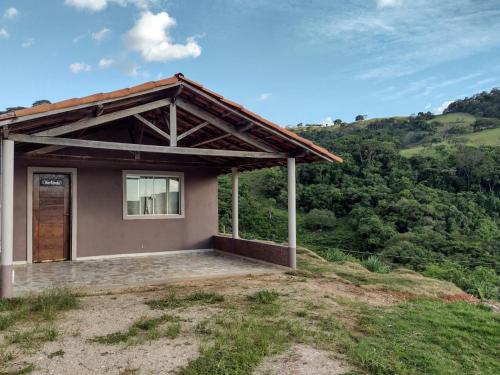 une petite maison au sommet d'une colline dans l'établissement Chalés Recanto das Flores, à Bueno Brandão