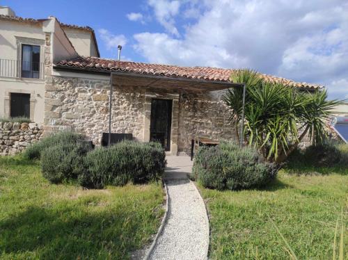 a stone house with a pathway in front of it at BRAMASOLE Charming House in Comiso