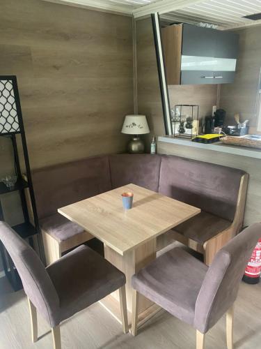 una mesa de madera con 2 sillas, una mesa y una lámpara en Vakantie Bos Huisje “Meibloempje”, en Lanaken