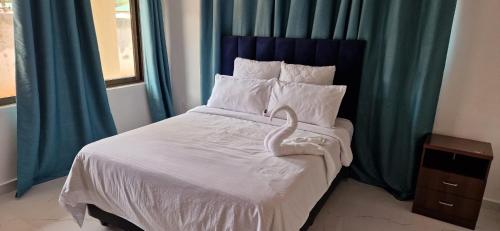 a bedroom with a bed with a swan on it at Shalom Apartments Kalumbila in Musele