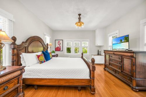 a bedroom with a bed and a dresser and windows at Birds of Paradise: Unwind in Nature's Embrace in Lantana