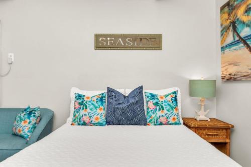 a bedroom with a bed with pillows and a sign that readsasha at Birds of Paradise: Unwind in Nature's Embrace in Lantana