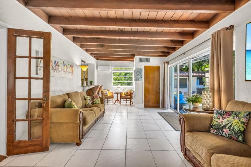 a living room with two couches and a table at Birds of Paradise: Unwind in Nature's Embrace in Lantana