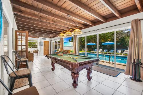 a pool table in a room with a swimming pool at Birds of Paradise: Unwind in Nature's Embrace in Lantana