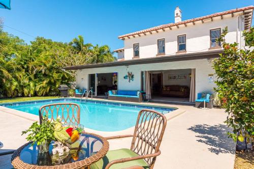 a house with a swimming pool and two chairs and a table at Birds of Paradise: Unwind in Nature's Embrace in Lantana