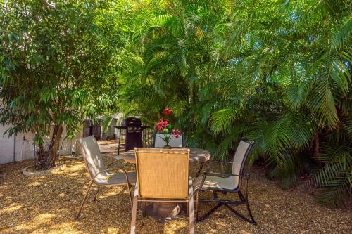 a table and chairs and a table and trees at Birds of Paradise: Unwind in Nature's Embrace in Lantana