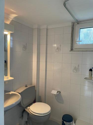 a white bathroom with a toilet and a sink at POTIDAIA BEACH HOUSE in Nea Potidaea