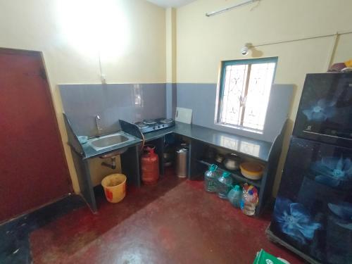 eine kleine Küche mit einem Waschbecken und einem Waschbecken in der Unterkunft Green cottage in Gokarna
