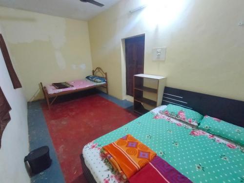 Kleines Zimmer mit einem Bett und einem Tisch in der Unterkunft Green cottage in Gokarna