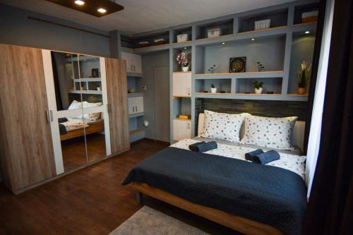 1 dormitorio con 1 cama grande y espejo en Marco Art Vendégház for 1- 8 persons, 