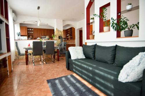 sala de estar con sofá y comedor en Marco Art Vendégház for 1- 8 persons, 