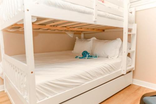 a white bunk bed with a teddy bear sitting on it at Sojourn Sanctuary Seaside Escape 3 BR in Virginia Beach