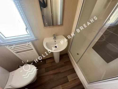 a bathroom with a toilet and a sink and a shower at Modern 3 bed; West Sands @ Seal Bay Resort in Chichester