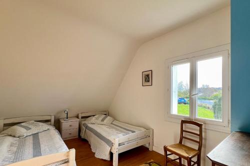 une chambre avec deux lits et une fenêtre dans l'établissement Maison familiale 10 p, à pied des plages de Port-Blanc, à Penvénan