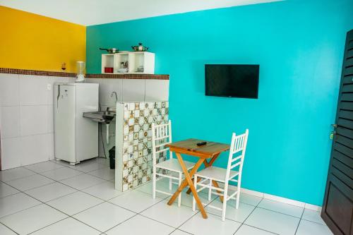 a kitchen with a table and a blue wall at Pousada Flat Castor in Natal
