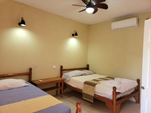 a bedroom with two beds and a ceiling fan at Ometepe House in Moyogalpa