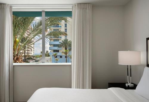 a bedroom with a window with a view of a hotel at Residence Inn by Marriott Miami Beach Surfside in Miami Beach