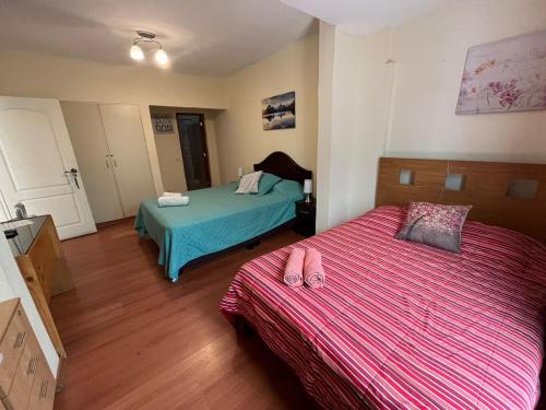 1 dormitorio con 2 camas con chanclas en Uli´s house, en Lima