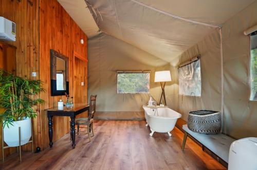 La salle de bains est pourvue d'une baignoire et d'un lavabo dans une tente. dans l'établissement Hill Country Safari Tent and Recreational Pavilion and Cowboy Pool!, à Dripping Springs