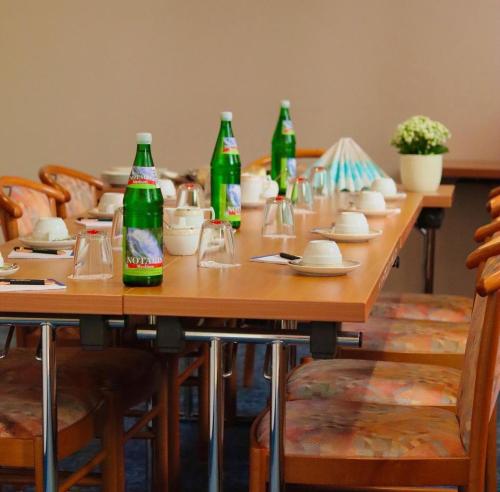 un lungo tavolo di legno con bottiglie di soda di Hotel Ilbertz Garni a Colonia