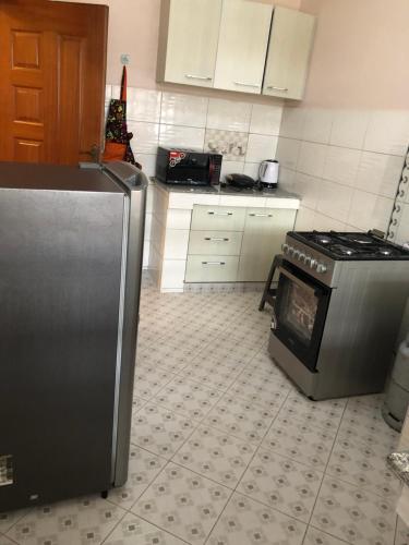 a kitchen with a refrigerator and a stove at Vogue Homes in Nakuru