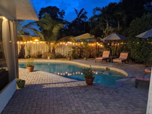 a swimming pool in a backyard at night at The Ave House- Private Oasis Retreat W/heated Pool in Fort Lauderdale