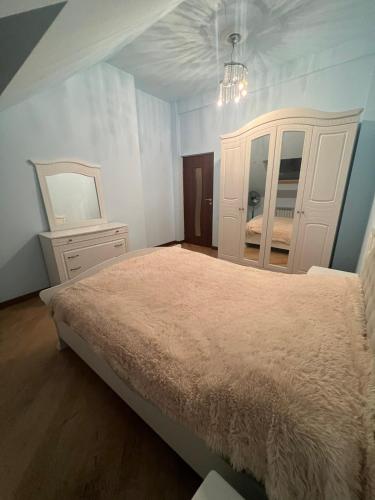 a bedroom with a bed and a dresser and a mirror at Opera Guest House in Yerevan
