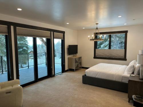 1 dormitorio con 1 cama y balcón en Whitefish Mountain Marvel Ski in Ski out- New Build, Pool Table, Hot Tub and Sleeps 19!, en Whitefish